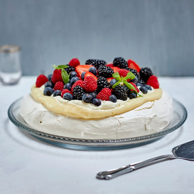 Pavlova med vaniljecreme, sommerbær og friske krydderurter